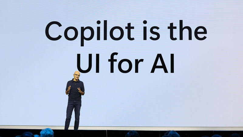 Satya Nadella auf der Bühne der Microsoft Ignite 2024. Auf einer Leinwand hinter steht zu "Copilot is the UI for AI"