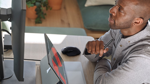 Man facing laptop wearing a blue vest