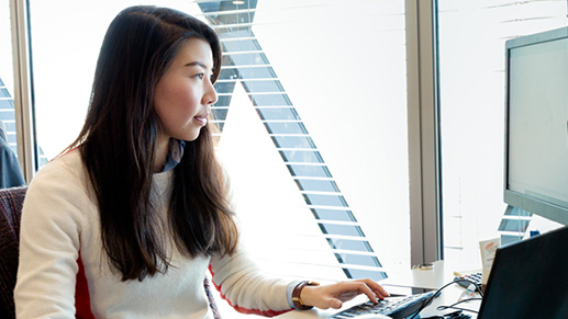 Woman wearng white shirt working at a desk