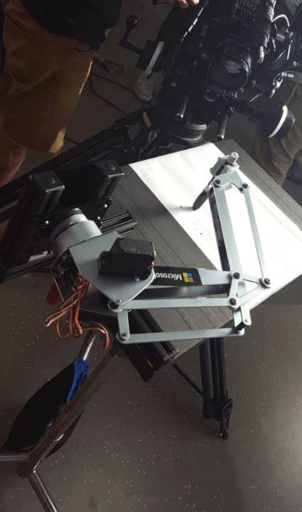 Photo of a robot arm writing the signature on a draft board